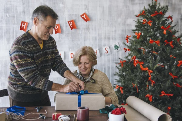 Älteres Ehepaar schmückt Weihnachtsgeschenk — Stockfoto