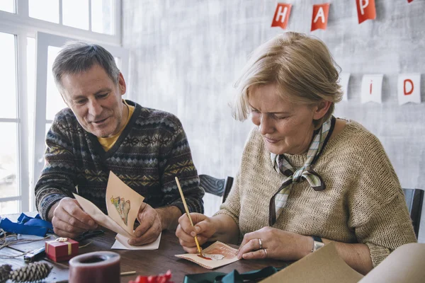 Couple painting Christmas cards together