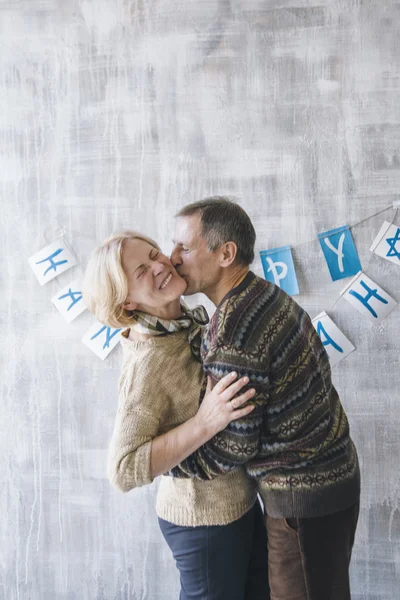 Paar küsst und umarmt sich an der geschmückten Wand — Stockfoto