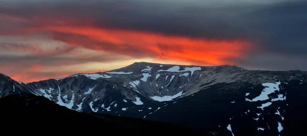 Atardecer dramático en las montañas. Cielo rojo y silueta de montaña en el atardecer — Foto de Stock