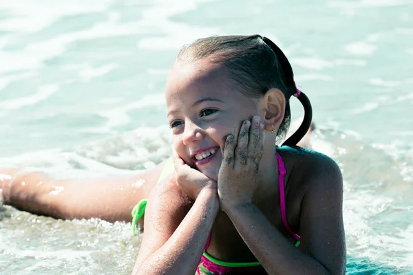 Chica feliz acostada en la orilla del mar — Foto de Stock