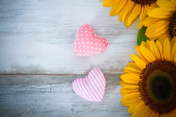 Sfondo con cuori di stoffa e girasoli — Foto Stock