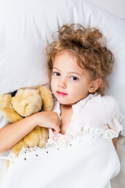 küçük kız yatakta herpes virüsü ile