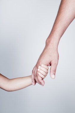 çocuk babasının elini tutar