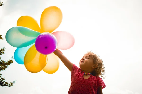 Liten flicka med ballonger — Stockfoto