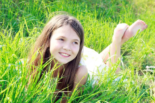 Menina deitada na grama verde — Fotografia de Stock