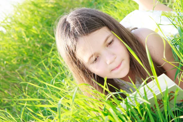 Flicka som läser på gräsmattan — Stockfoto