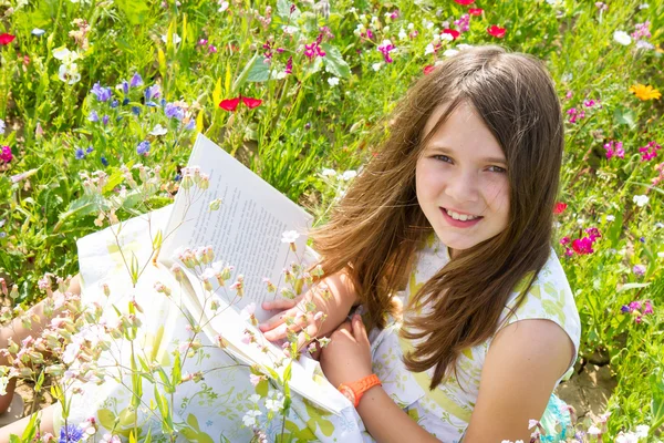 Girl in field with book — Stock Photo, Image
