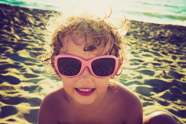 Liten flicka med solglasögon på stranden — Stockfoto