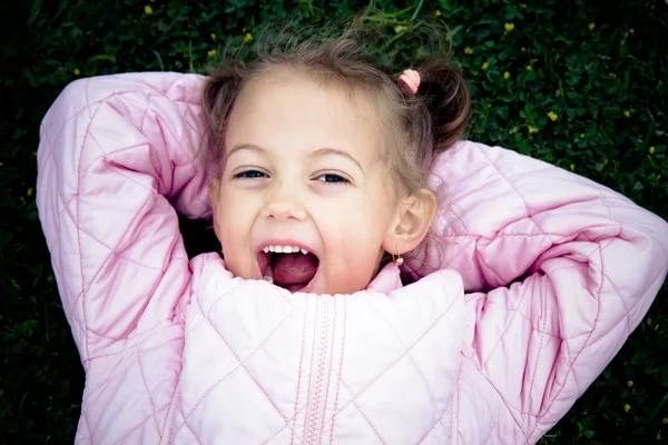 Joyful little girl on the lawn — Stockfoto