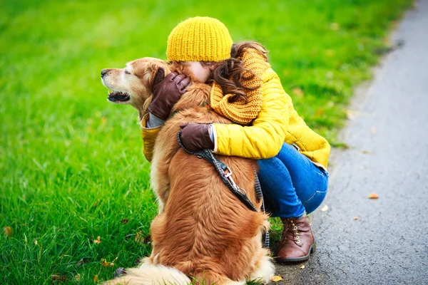 Kind kuschelt mit Hund — Stockfoto