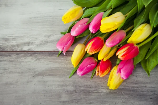 Tulipanes coloridos en la mesa de madera — Foto de Stock