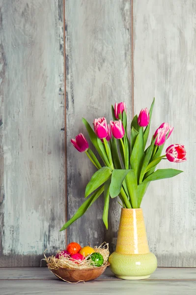 Red tulips and plate with eggs — Stock Photo, Image