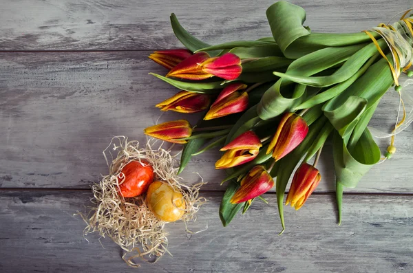 Fondo colorido con huevos de Pascua y tulipanes — Foto de Stock