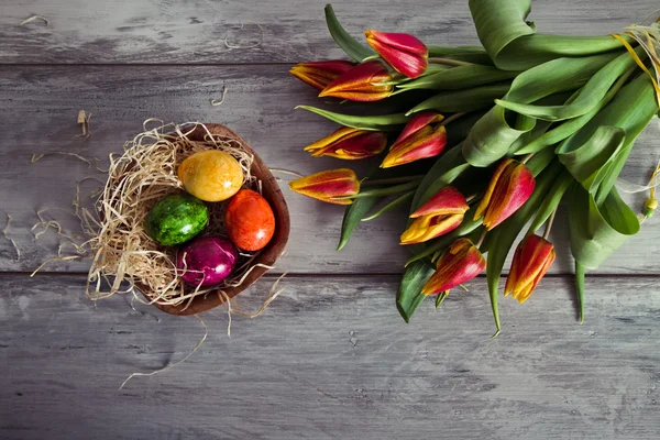 Tulipanes y huevos de Pascua sobre fondo de madera — Foto de Stock