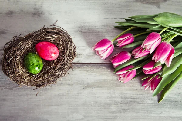Tulipanes rosados y huevos en el nido — Foto de Stock