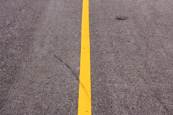 Nowa droga asfaltowa z żółtej linii przed zachodem słońca — Zdjęcie stockowe