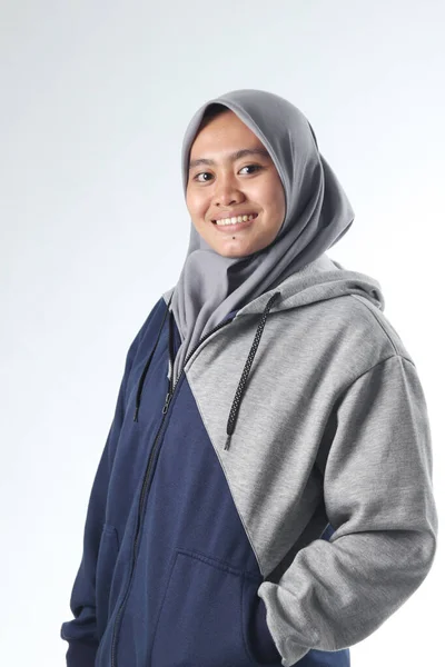 Sıradan kıyafetler giyen Asyalı bir kadının portresi. Gri ceketli kapüşonlu kadın beyaz arka planda izole edilmiş.