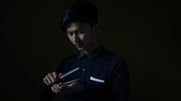 Portrait Asian Man Sharpening Knife Eerie Expression Dark Room Concept — Stock Video