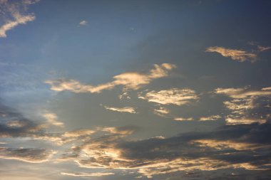 Öğleden sonra açık mavi gökyüzü. Gün batımında parlak turuncu bulutlar