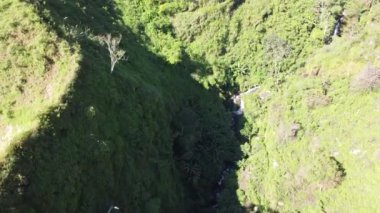 Ringgit Dağı, Doğu Java 'da havadan şelale. Dağ kayalıkları arasındaki şelale manzarası. Sabah yeşil dağların manzarası