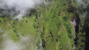 Ringgit Dağı, Doğu Java 'da havadan şelale. Dağ kayalıkları arasındaki şelale manzarası. Sabah yeşil dağların manzarası