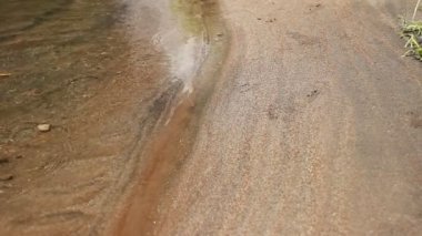 Nehir kahverengi kumla hızlıdır. Akan suyun sesiyle rahatlamak için taze doğa kavramı. Çöp ve lağım gübresi olmayan temiz nehir kıyıları