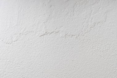 Duvar görünür bir dokuya sahip beyaz boyayla boyanmıştır.