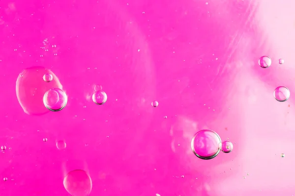 Σταγόνες Λαδιού Στο Νερό Ροζ Φόντο — Φωτογραφία Αρχείου