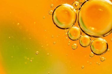 Turuncu arkaplandaki suya yağ damlaları