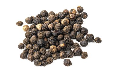 Beyaz zemin üzerinde görünür bir dokusu olan siyah biberler.