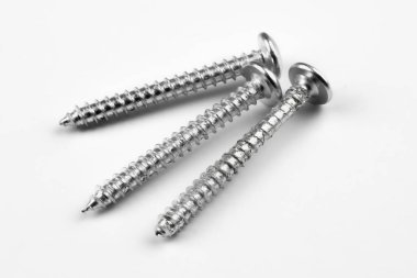 Beyaz arka planda gümüş vidaların makro fotoğrafı