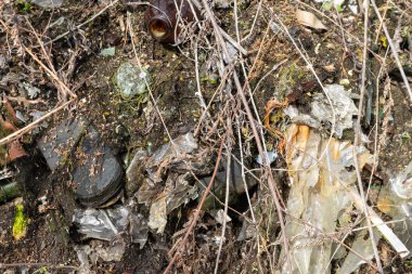 Vahşi çöp yığını. Kalan camlar, ormandaki plastikler.