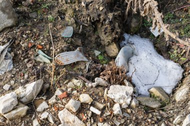 Vahşi çöp yığını. Kalan camlar, ormandaki plastikler.