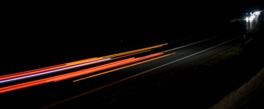 Geceleri hareket halindeki arabaların ışıkları. uzun pozlama