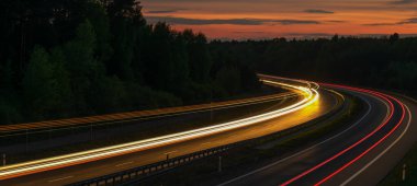 Geceleri hareket halindeki arabaların ışıkları. uzun pozlama