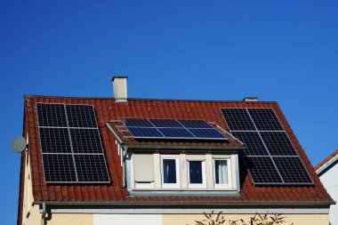 Wohnhausdach mit Dachgaube belegt mit Photovoltaik Panelen