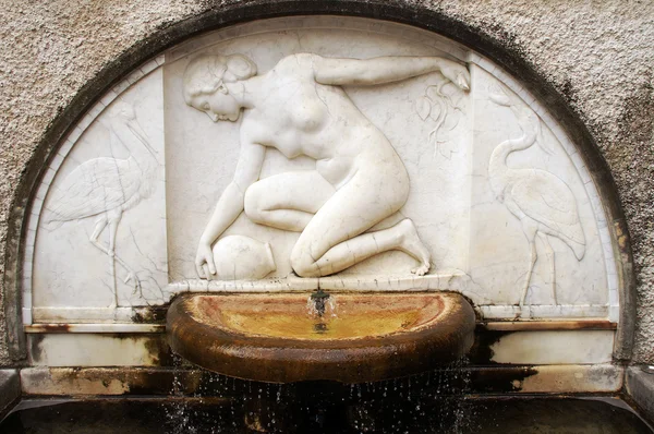 Vatten-lägga till kvinnan i halv-relief - fontän skulptur av en gammal villa — Stockfoto
