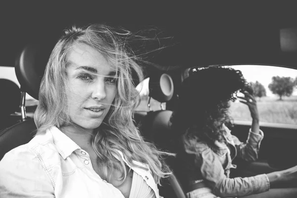 Dvě dívky, jízdy po cestě v autě theire — Stock fotografie