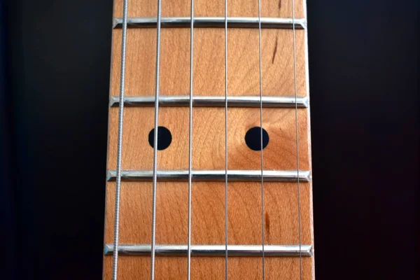 Electric guitar background. Maple fretboard and strings close-up.
