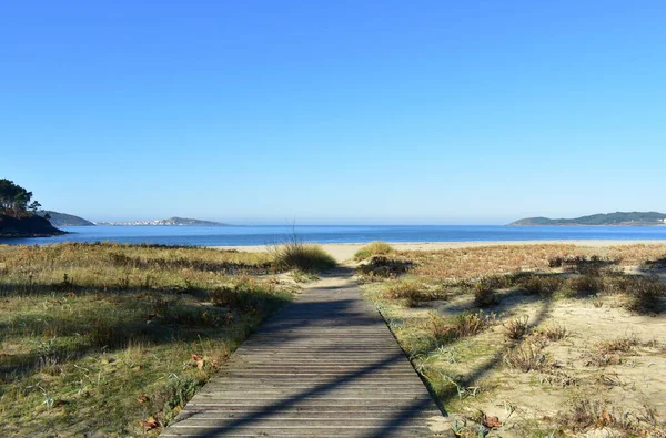 有名なリアス バイシャス地方で木製のボードウォークを持つビーチ Muxia Corua Galicia スペイン ロイヤリティフリーのストック写真