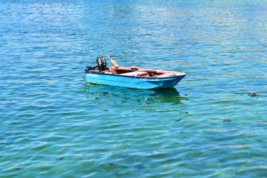 Portosin, Spain. July 3, 2020. Old red and blue wooden small boat floating on the sea at famous Rias Baixas in Galicia Region.