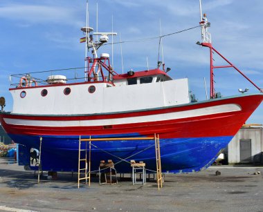 Limandaki geleneksel mavi, kırmızı ve beyaz Galiçyalı balıkçı teknesi. Galiçya, İspanya.