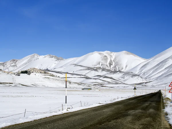 Asphalt straight road along  plateau of Castelluccio of Norcia i — Stock Photo, Image