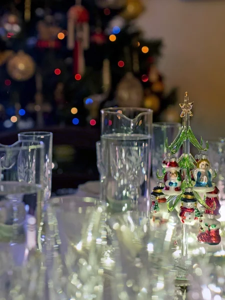 Bril en decoratie voor kerstdiner in de buurt van de kerstboom — Stockfoto