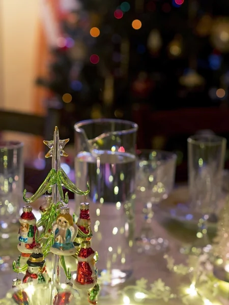 Glasses and decorations for Christmas dinner near christmas tree — Stock Photo, Image