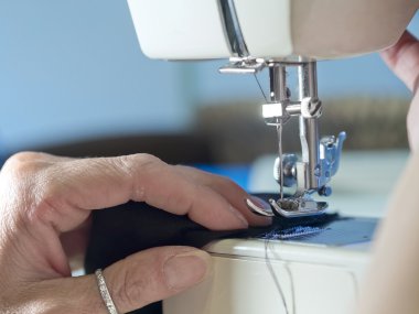 hand of  woman working with  old sewing machine