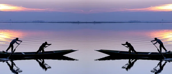 Venice sunset silhouette of sinchronized rowing men — Stock Photo, Image