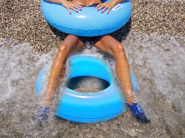 Deniz kıyısı kadına iki güzel tabaklanmış bacaklarını — Stok fotoğraf