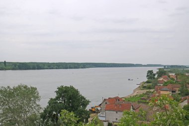 Geniş nehir, gri gökyüzü ve beyaz bulutlar.